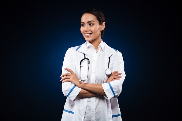 Jeune infirmière avec stéthoscope souriant et regardant de côté