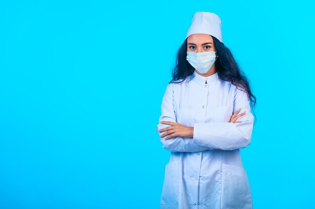 Jeune infirmière en uniforme isolé tenant les mains fermées et a l'air confiant