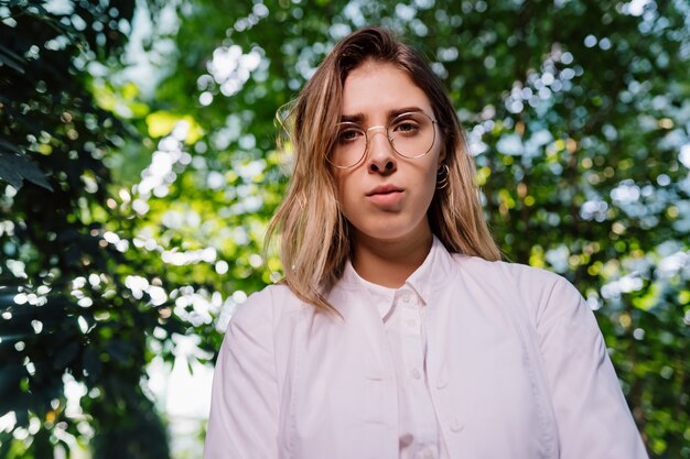 Jeune ingénieur agronome travaillant en serre. Jeune femme scientifique en regardant la caméra