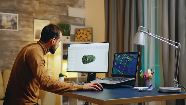 Jeune ingénieur dans son bureau à domicile travaillant sur le développement d'une nouvelle turbine. Interface logicielle.