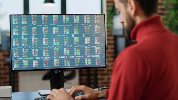 Photo gratuite jeune investisseur travaillant sur ordinateur avec des graphiques boursiers en temps réel, suivant la tendance des ventes du marché commercial. analyste financier utilisant les statistiques d'échange de devises pour planifier l'analyse des données, indexer les bénéfices. fermer.