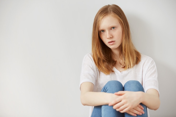 Photo gratuit jeune jolie adolescente assise sur le sol à la maison désespoir triste seul
