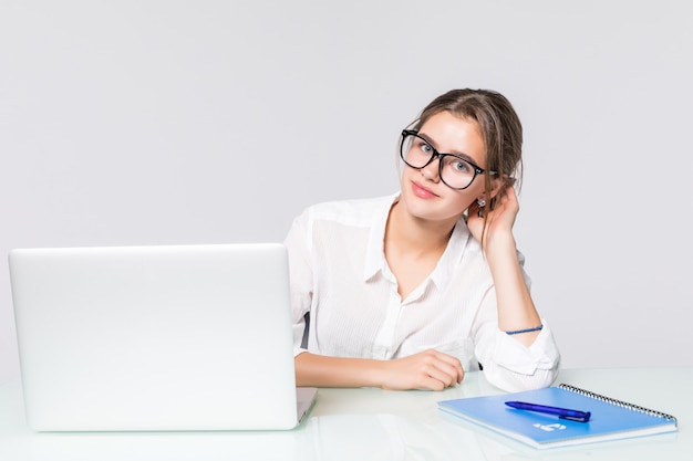 Jeune jolie femme d'affaires avec ordinateur portable dans le bureau isolé sur fond blanc