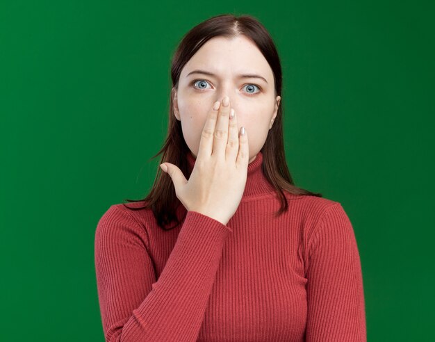 Jeune jolie femme concernée mettant la main sur la bouche