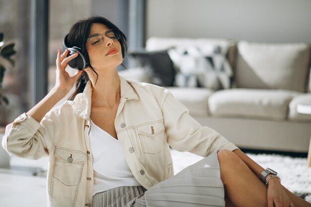 Jeune jolie femme écoutant de la musique sur des écouteurs sans fil