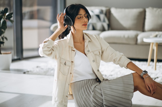 Jeune jolie femme écoutant de la musique sur des écouteurs sans fil