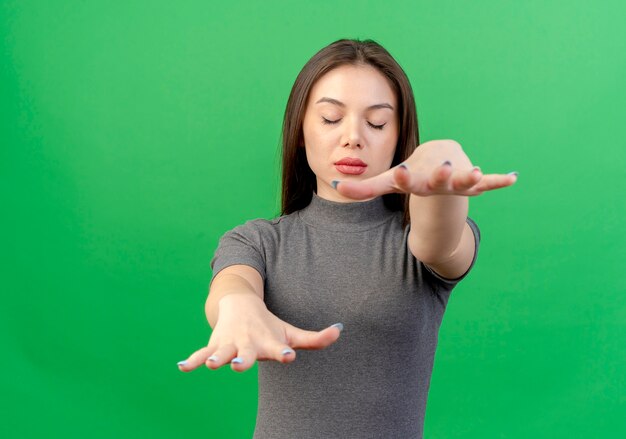 Jeune jolie femme étendant les mains et marchant les yeux fermés