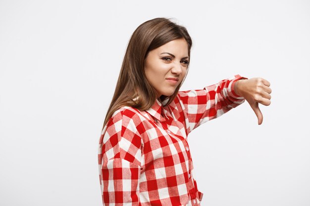 Jeune jolie femme faisant des grimaces et ne montrant aucun signe