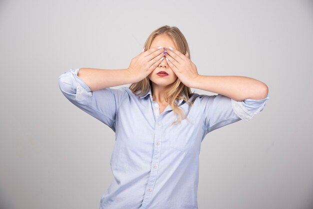 Photo gratuite jeune jolie femme fermant les yeux avec les mains