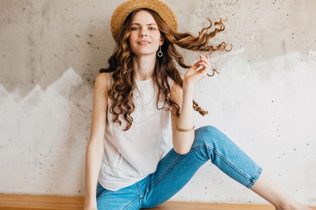 Jeune jolie femme heureuse souriante portant des jeans en denim bleu et chemise blanche