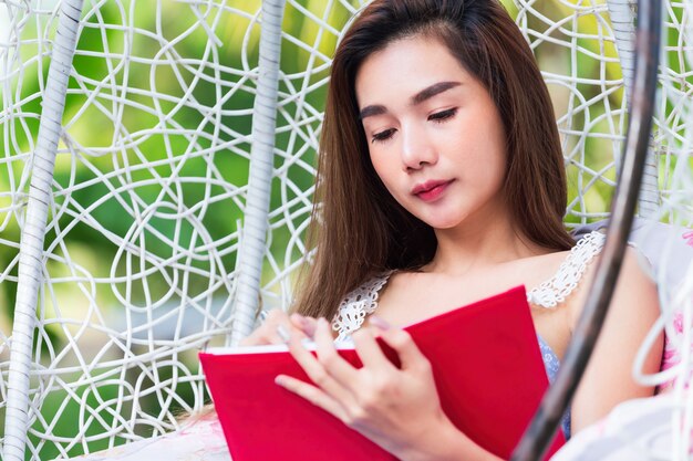 Jeune jolie femme avec un journal rouge dans le parc