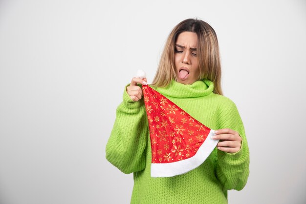 Jeune jolie femme posant au chapeau rouge du père Noël.