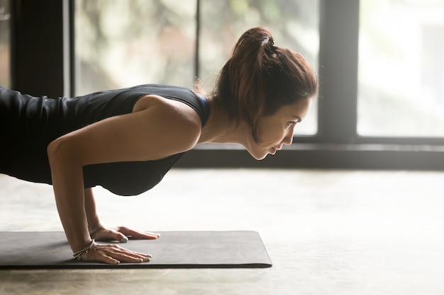 Photo gratuite jeune jolie femme en pose de chaturanga dandasana