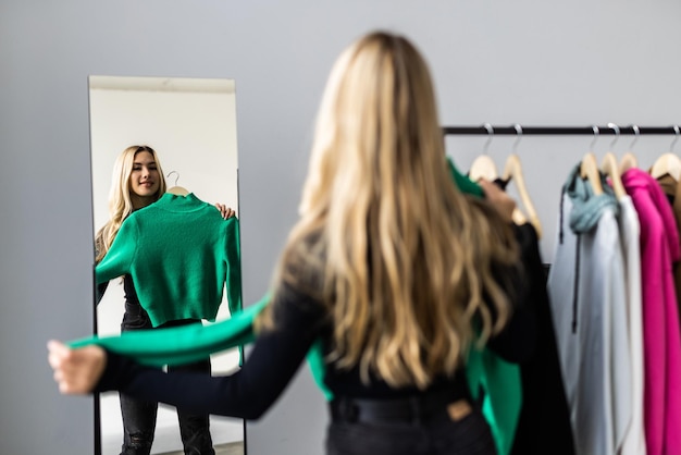 Photo gratuite jeune jolie femme regardant dans le miroir près de la garde-robe à la maison