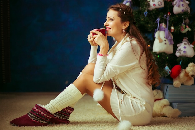 Photo gratuite jeune jolie femme sous l'arbre de nouvelle année