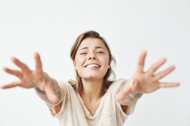 Jeune jolie fille drôle, souriant, étirant les mains à la caméra.