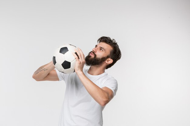 Jeune joueur de football avec ballon devant blanc