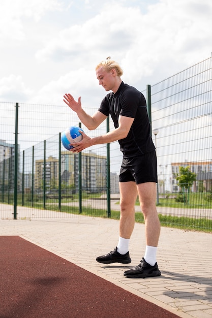 Jeune joueur de volley-ball dans la cour