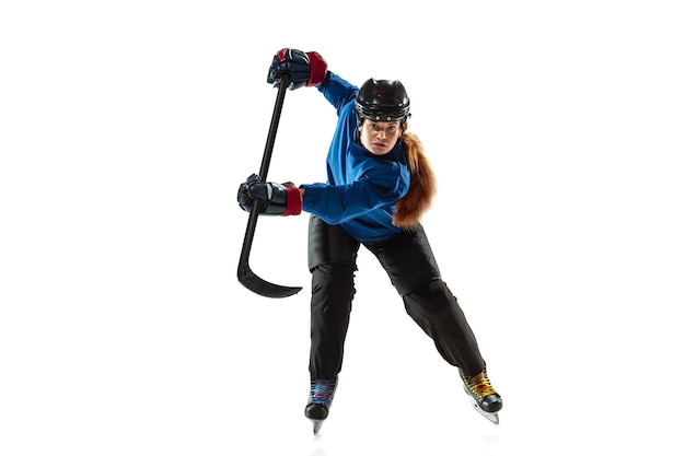 Jeune joueuse de hockey avec le bâton sur la glace et le mur blanc