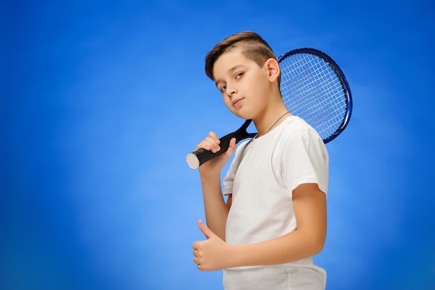 Jeune joueuse de tennis sur mur bleu