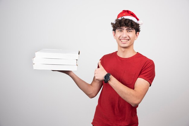 Jeune Livreur En Bonnet De Noel Donnant Les Pouces Vers Le Haut.