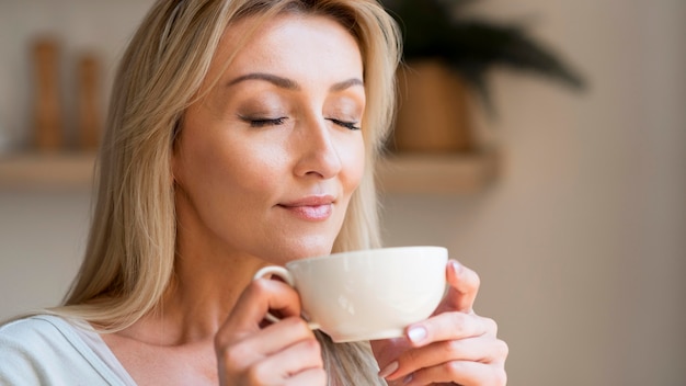 Jeune maman appréciant l'odeur du café