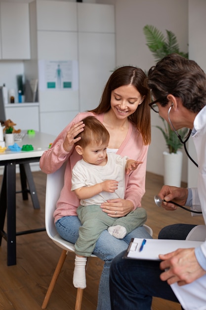 Jeune maman avec bambin chez le pédiatre pour une consultation