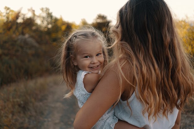 Une jeune maman joyeuse passe de merveilleuses vacances dans la forêt avec son enfant. Deux blondies, mère et fille