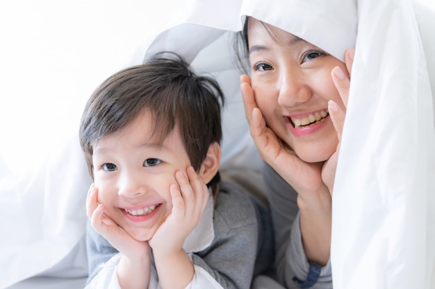 Jeune maman et petit garçon sous une couverture de bonheur