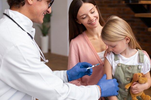 Jeune maman avec sa fille chez le pédiatre pour un vaccin