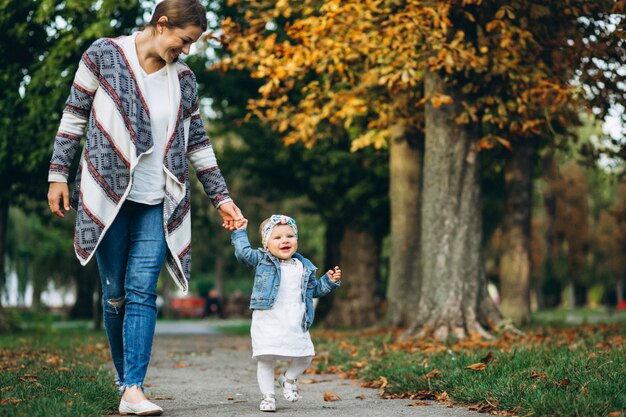 Jeune maman avec sa petite fille dans un parc en automne