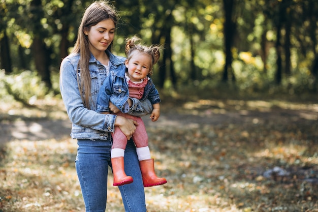 Jeune maman avec sa petite fille dans un parc en automne