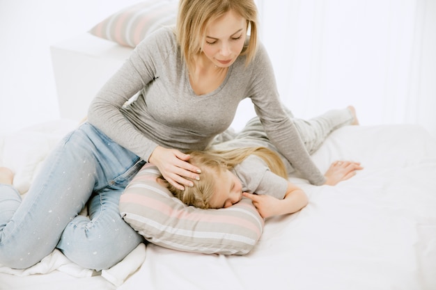 Jeune maman et sa petite fille à la maison au matin ensoleillé.