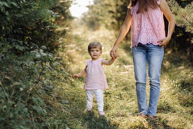 Jeune maman avec son adorable petit bébé en forêt