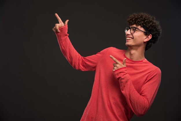 Jeune mannequin aux cheveux bouclés faisant la promotion de quelque chose.