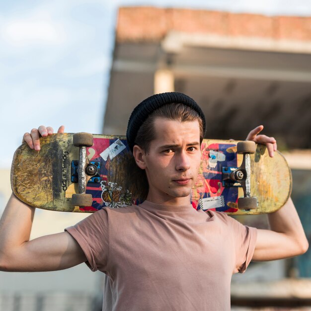 Jeune mannequin posant avec skateboard