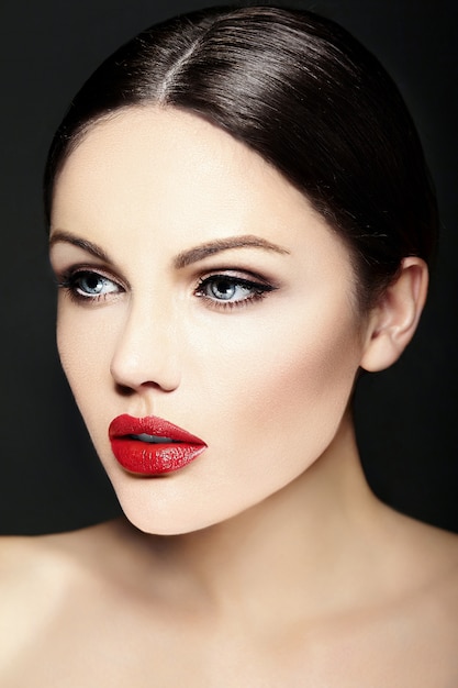 Jeune mannequin de race blanche avec un maquillage lumineux, une peau parfaitement propre et des lèvres rouges colorées