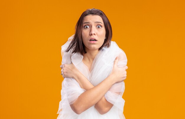 Jeune mariée en belle robe de mariée peur coning hersekf avec les mains debout sur l'orange