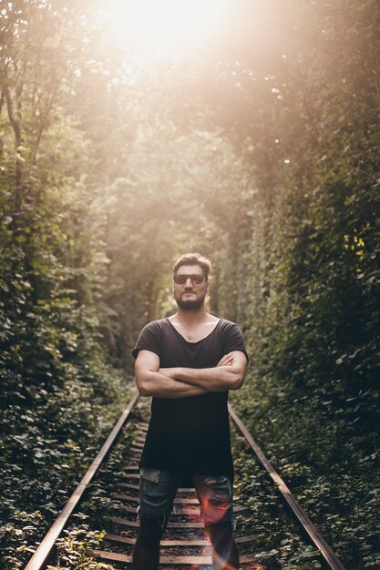 Jeune mec avec une barbe posant dans la rue au coucher du soleil