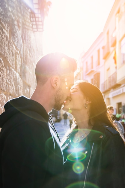 Photo gratuite jeune mec s'embrasser une dame heureuse dans la rue