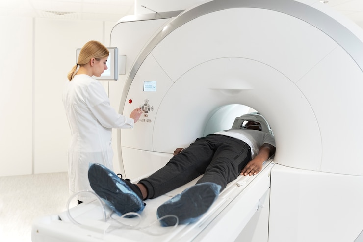 Photo gratuit jeune médecin à angle élevé en appuyant sur les boutons de tomodensitométrie