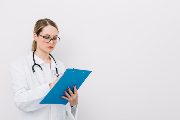 Jeune médecin écrit sur le presse-papiers