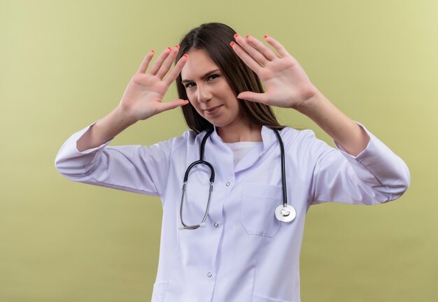 Jeune médecin fille portant une robe médicale stéthoscope - sur mur vert