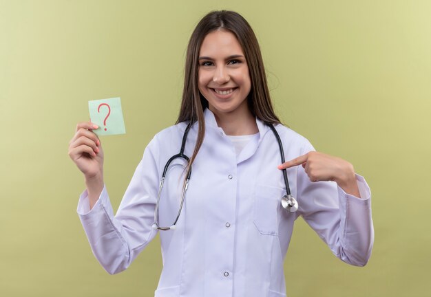 Jeune médecin fille portant une robe médicale stéthoscope - sur mur vert