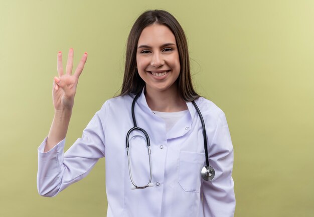 Jeune médecin fille portant une robe médicale stéthoscope - sur mur vert