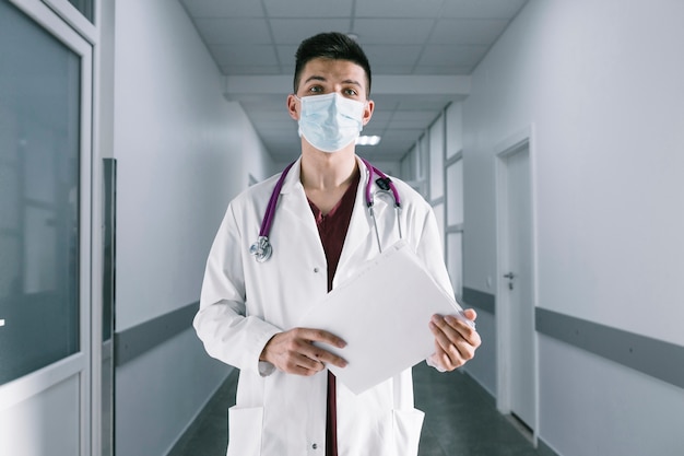 Jeune médecin en masque dans le hall