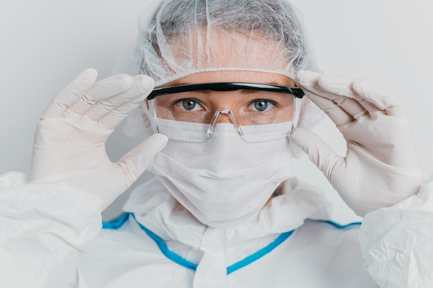 Jeune médecin mettant des lunettes de protection