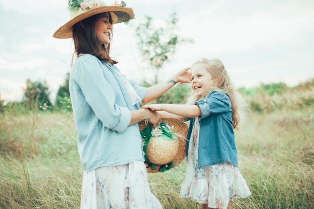 La jeune mère et fille sur fond d'herbe verte