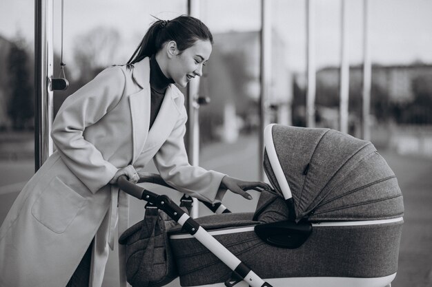 Jeune, mère, marche, voiture bébé, dans parc