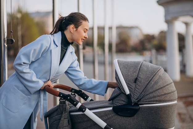 Jeune, mère, marche, voiture bébé, dans parc